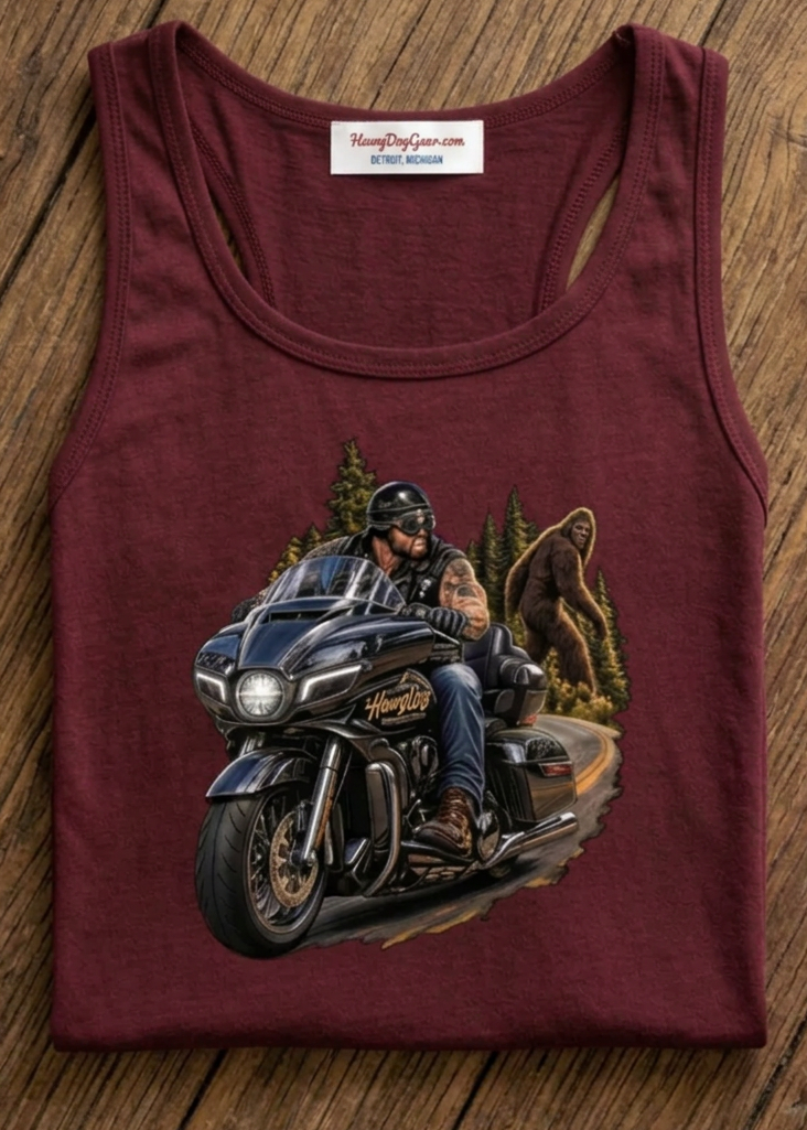Front of the maroon Follow The Unknown women's crewneck tank with the Bigfoot motorcycle graphic, laid flat on a wooden table