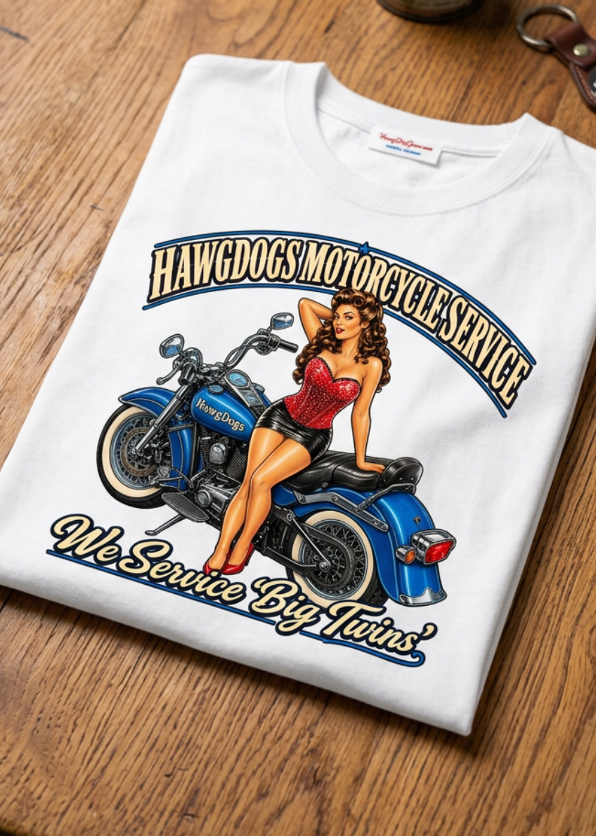 Front of the white Betty Big Twins men's tank top with the pin-up motorcycle graphic, laid flat on a wooden table