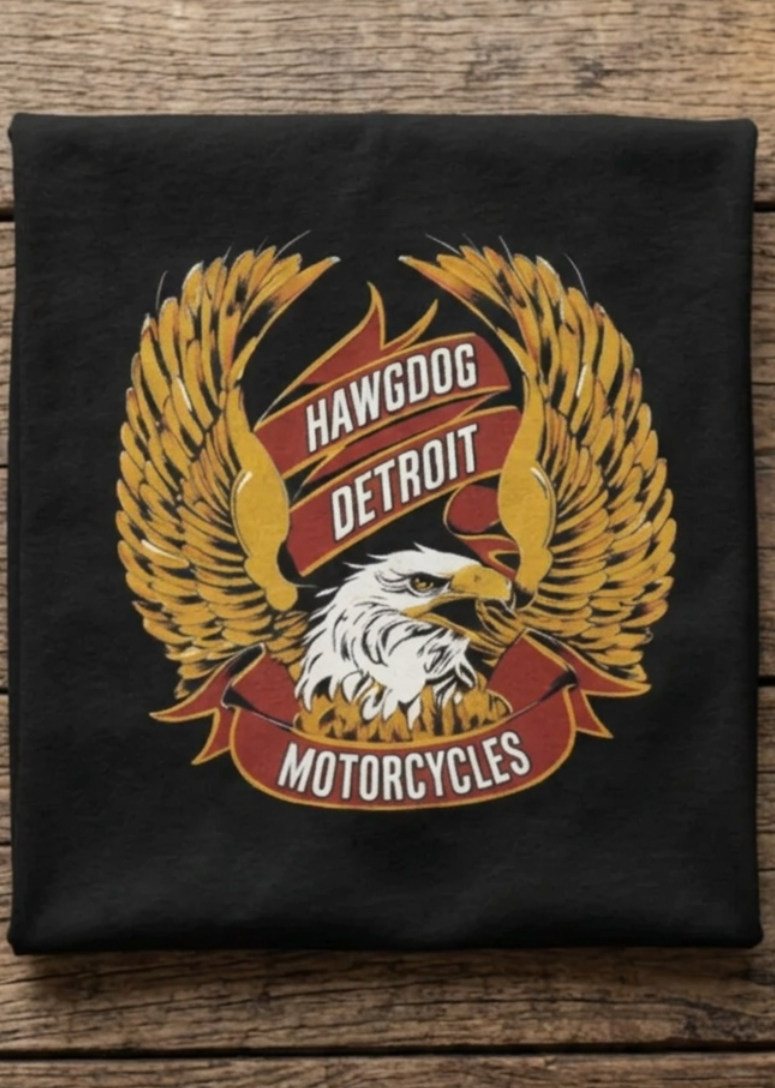 Front of the black Classic Gold Eagle women's crewneck tank with the gold eagle graphic, laid flat on a wooden table