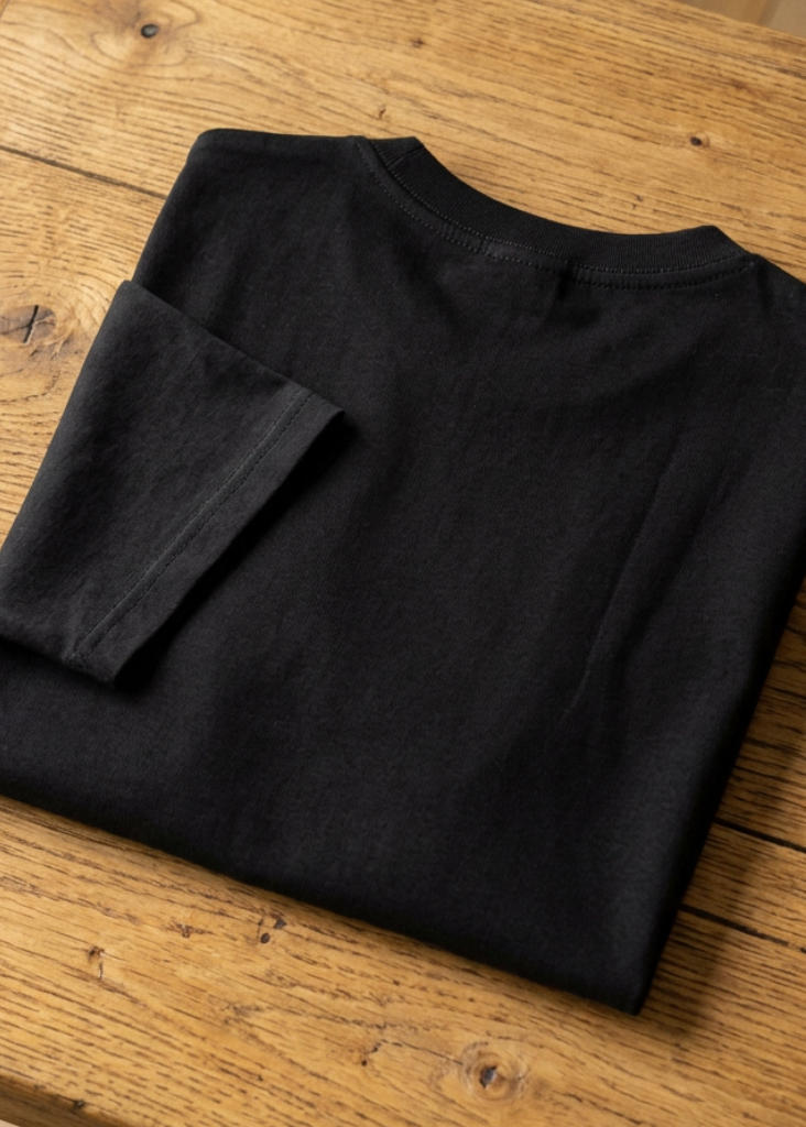 Back of the black Don't Fear Death, Fear Not Living tee, folded on a wooden table