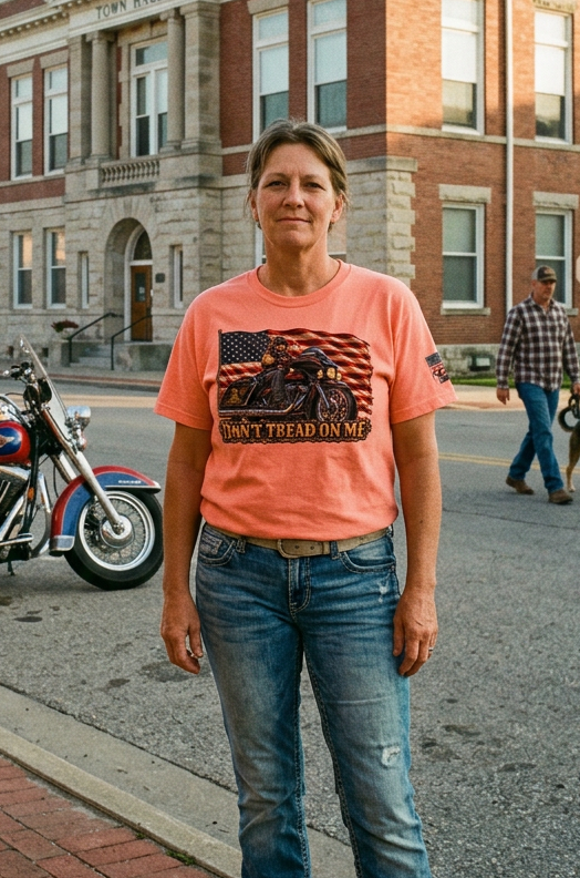 Woman in the coral Don't Tread Doggo tee on a small town main street with motorcycles