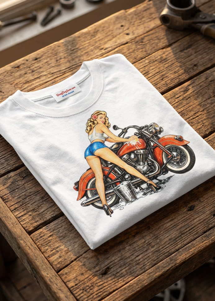 Front of the white Polishing Patty men's tank top with the pin-up biker graphic, laid flat on a wooden table