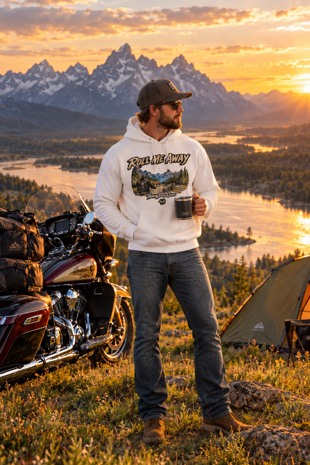 Man in the white Roll Me Away hoodie by his motorcycle at a mountain lake