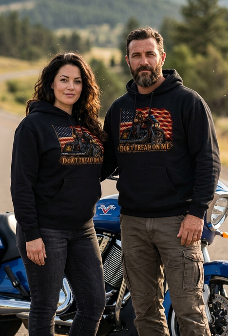 Couple in black Don't Tread Doggo hoodies with a motorcycle in the hills