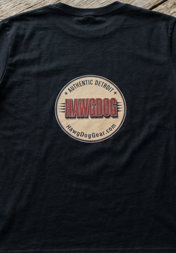 Back of the black Bagger Dogs tee with the Authentic Detroit patch, folded on a wooden table
