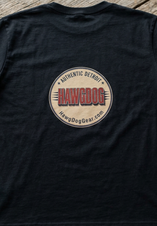 Back of the black Bagger Dogs tee with the Authentic Detroit patch, folded on a wooden table