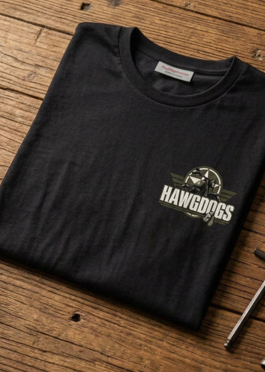Front of the black Might of The Republic rear print tee with the small HawgDogs chest logo, laid flat on a wooden table