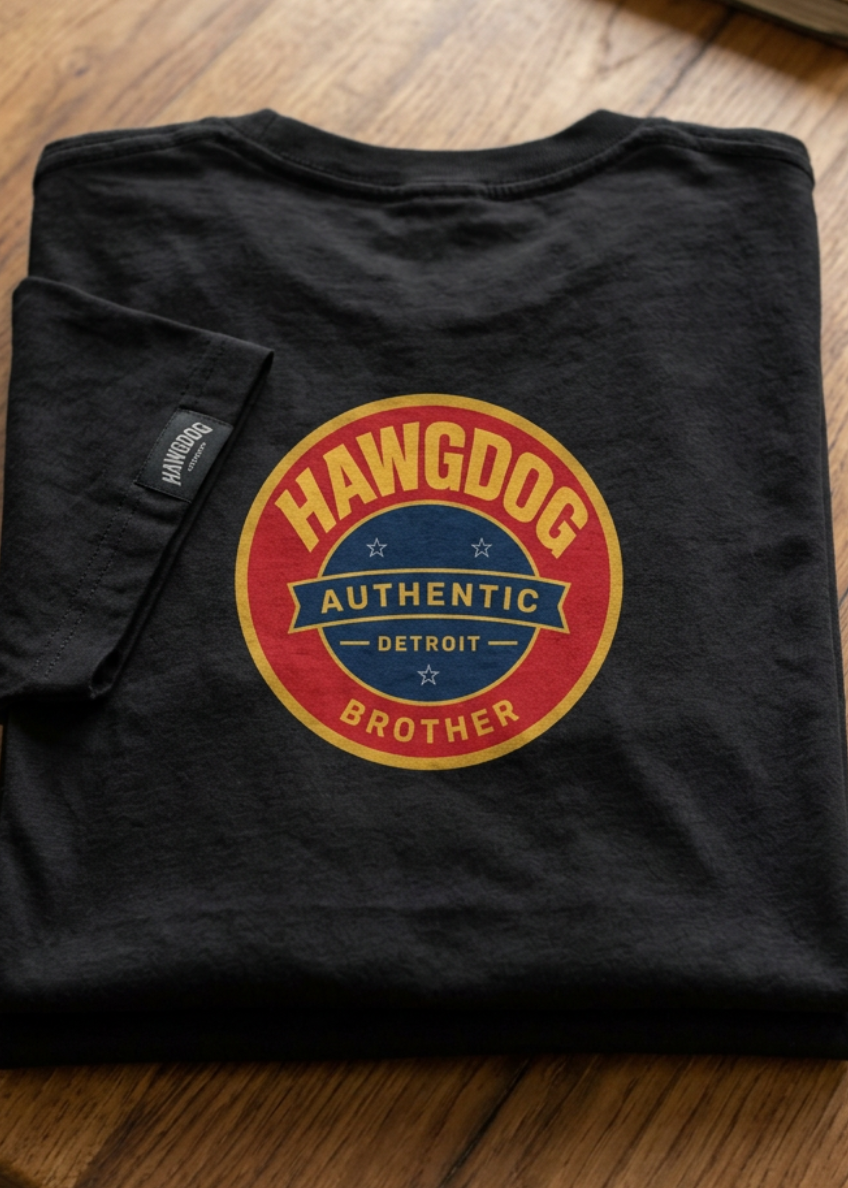Back of the black The Barkster tee with the HawgDog Authentic Detroit Brother patch, folded on a wooden table
