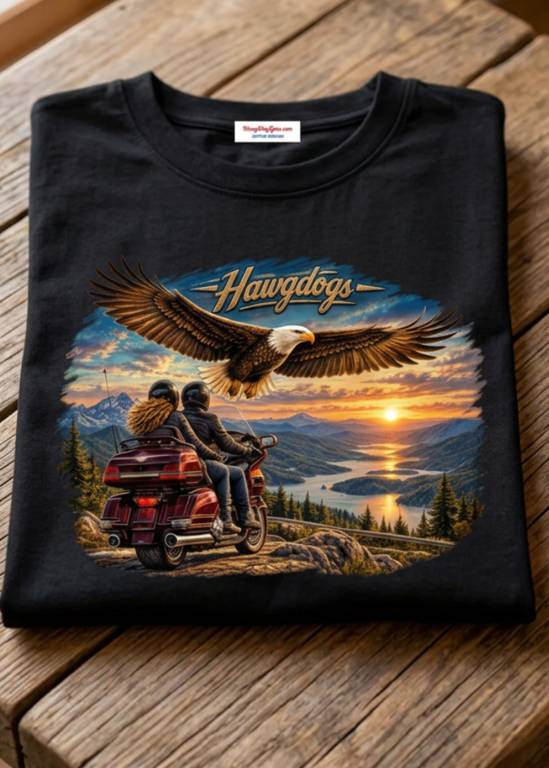 Front of the black Wings of The Open Road men's tank top with the soaring eagle and sunset motorcycle graphic, laid flat on a wooden table